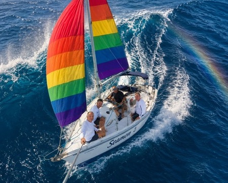 Seamen sailing with rainbow sail from overhead